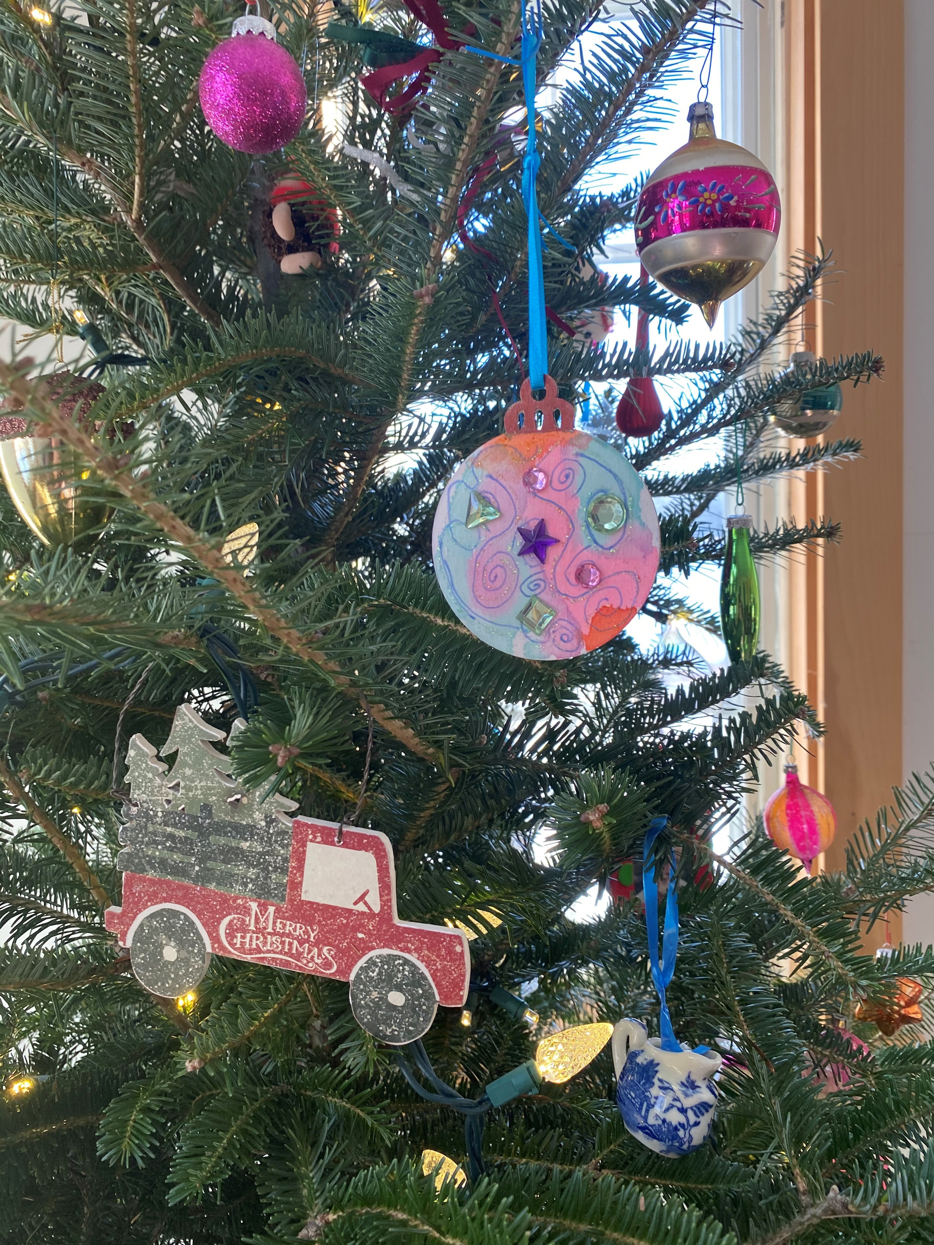 Two handmade ornaments created by Jan hanging on a Christmas tree.